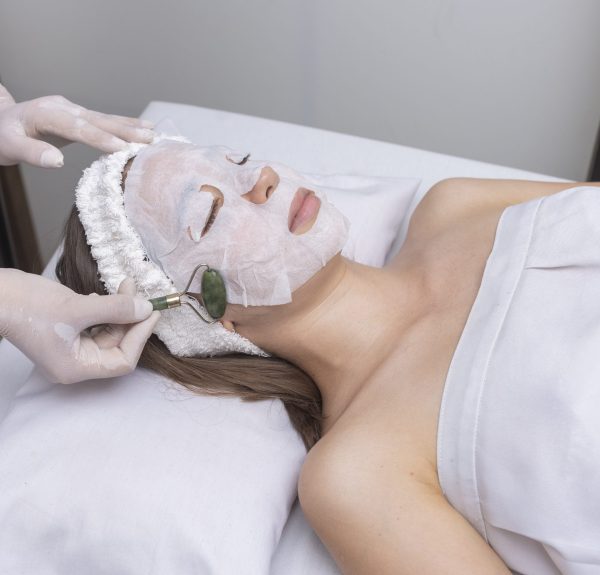 A closeup of a facial aesthetic massage with jade stone