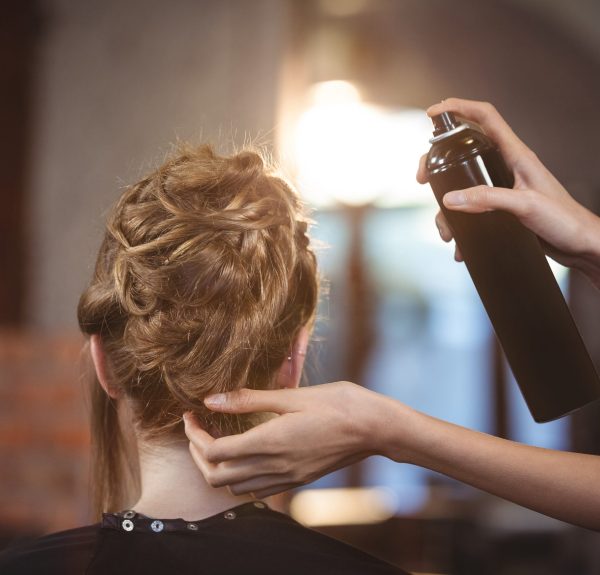 Female hairdresser styling customers hair at a salon