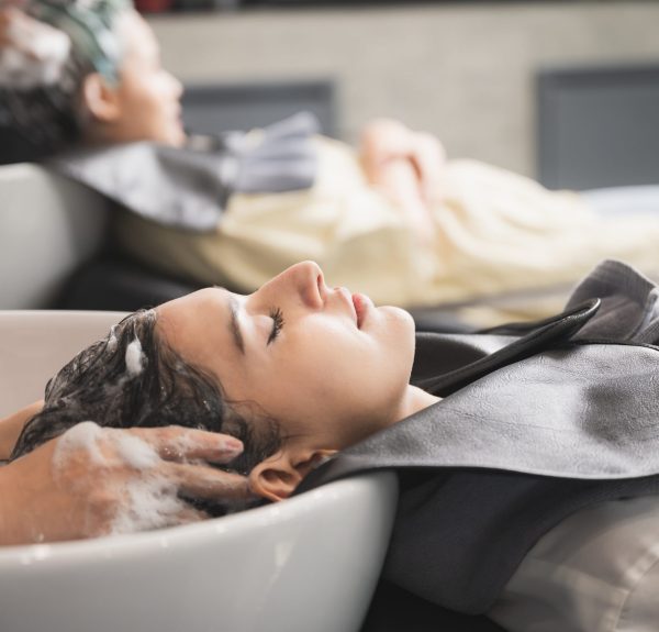 young woman hairdresser in salon, hair care beauty fashion with female girl